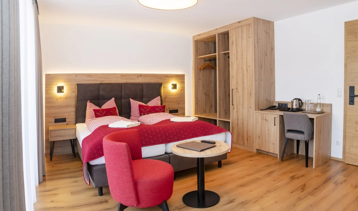Barrierearmes Zimmer: heller Holzboden, kontrastreiche Möbel, viel Licht, freie Flächen für gute Orientierung.